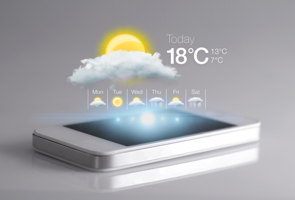 Smartphone with weather icon on light grey background.